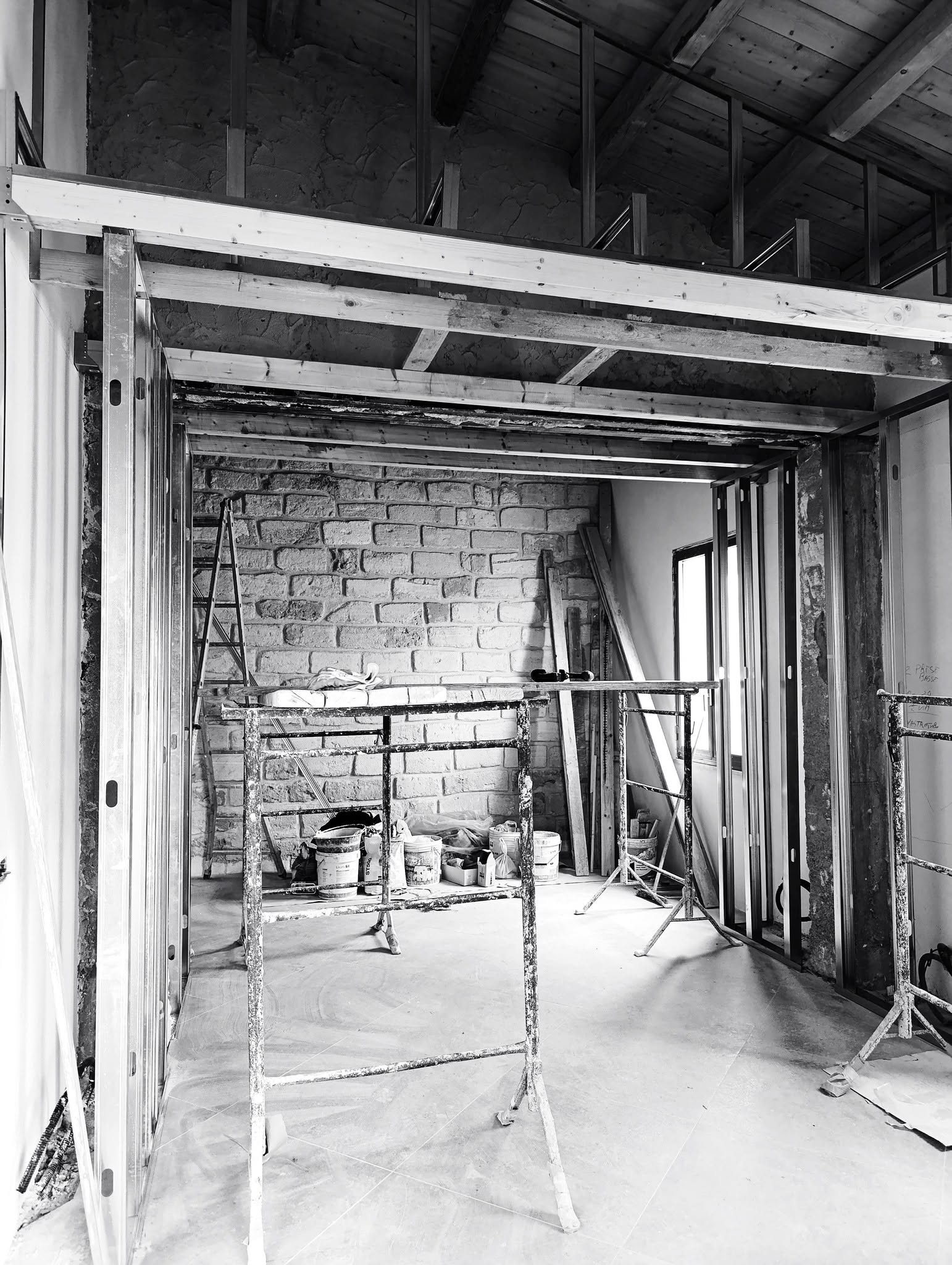 Cantiere in bianco e nero con travi in legno e telai in acciaio